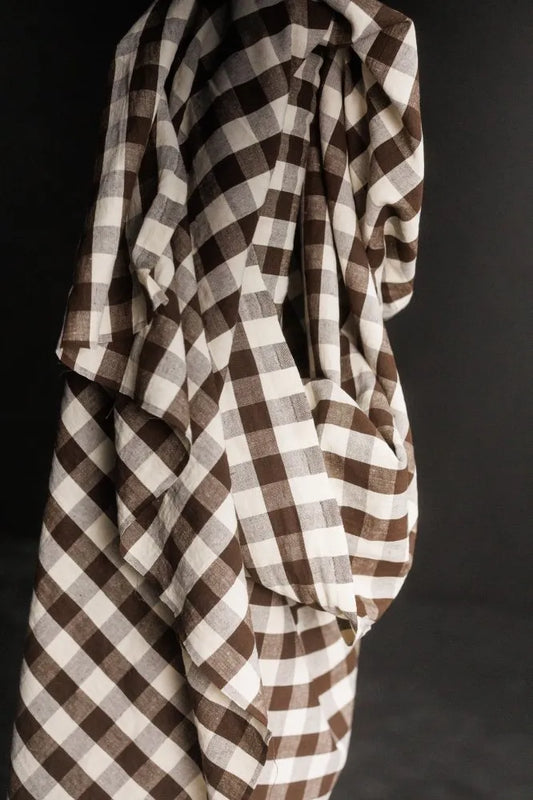 Brown and white checkered fabric draped over a dark background