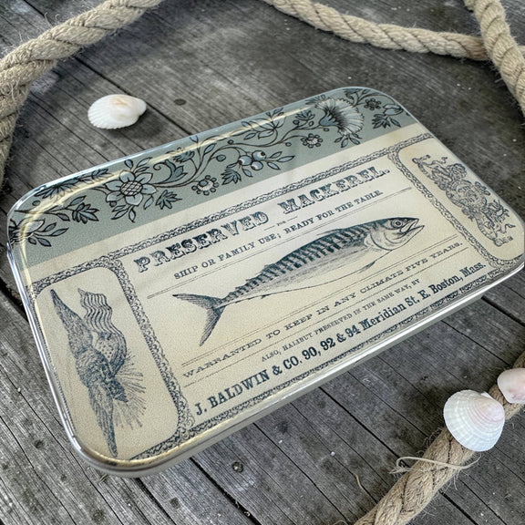 Decorative tray with vintage-style fish label design on a wooden surface with rope and shells.