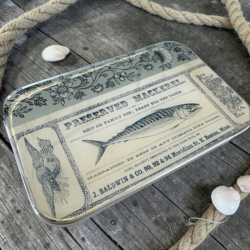 Decorative tray with vintage-style fish label design on a wooden surface with rope and shells.